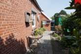 Durchgang zum Garten Bild II - Liebevoll gepflegtes Einfamilienhaus mit wunderschön angelegtem Garten in Simonswolde