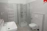 Badezimmer mit Dusche - Attraktive Erdgeschosswohnung im schönen Neubau und zentraler Lage von Wiesmoor!